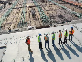 Photo prise en hauteur d'un groupe de personnes sur un chantier avec gilets et casques de sécurité
